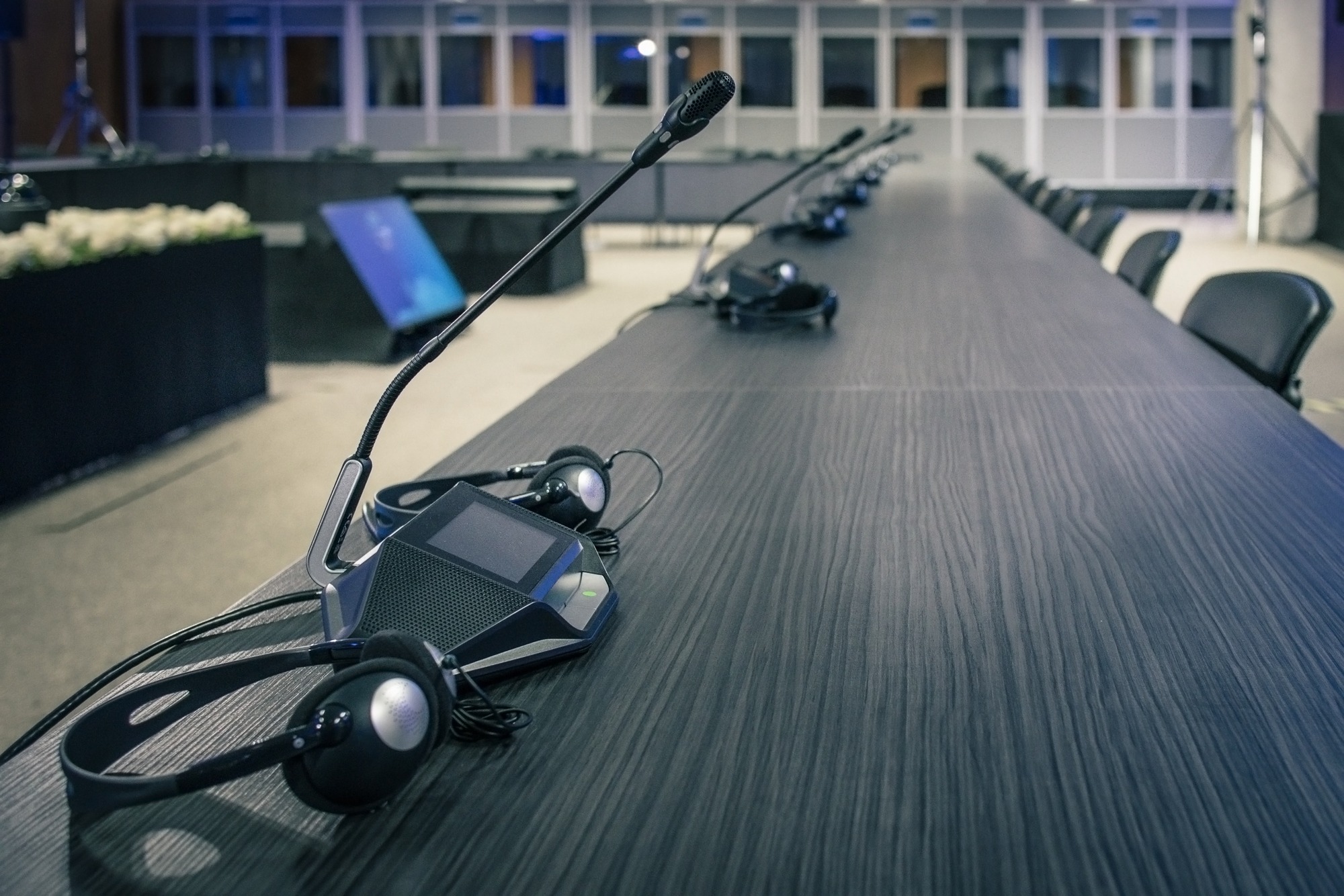 Conference table set with microphones and headsets for multilingual discussions. The setup indicates preparation for a collaborative meeting or event.